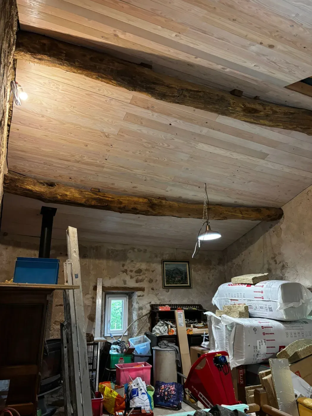 Poutre de charpente ancienne conservée sous un plafond lambrissé